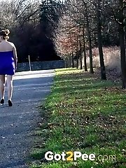 15 pictures - Brunette pees as she leans on a wall