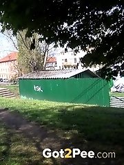 15 pictures - Dark haired woman is filmed pissing by a tree