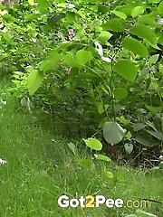 15 pictures - Cute brunette squats to piss over a woodland path