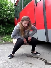 15 pictures - Busty brunette pees behind a bus
