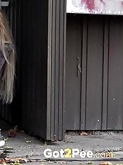 15 pictures - Cute blonde pisses in public in the city